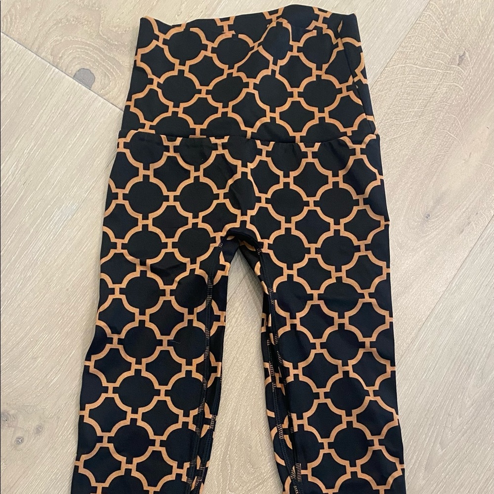 K-Deer Capri length black and gold leggings.